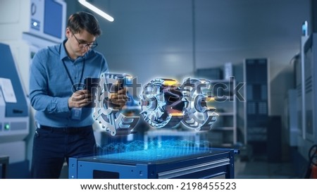 Factory Office Facility: Chief Engineer Developer Holds Tablet Computer, Examins Augmented Reality Model of an Electric Generator. Modern Industry 4.0 Research and Development Center Concept. Royalty-Free Stock Photo #2198455523