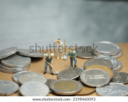 Financial and economy conceptual design with money coin. Unfocus many stuff at table. Background is blurred. Toy photography concept.