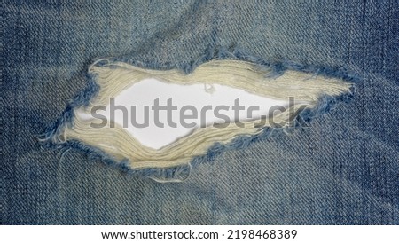 Blue torn denim jeans texture with white space for text.