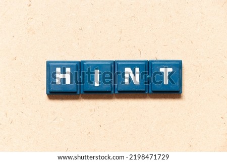 Tile letter in english word hint on wood background Royalty-Free Stock Photo #2198471729