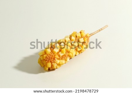 Delicious Crunchy Korean Style Chunky Potato Corn Dogs with Batter and Fried Potatoes. Isolated on Cream Background with Copy Space for Text Royalty-Free Stock Photo #2198478729