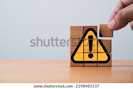 Hand assemble yellow exclamation caution sign or warning symbol print screen on wooden block on dark background for notification error and maintenance concept. Royalty-Free Stock Photo #2198483137