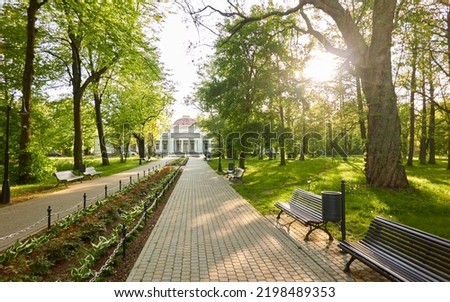 Alley in city park. Benches, floral decoration, bicycle road, trees, flowers, plants. Liepaja, Latvia. Summer landscape. Public places, urban planning, landscaping design, gardening, recreation themes Royalty-Free Stock Photo #2198489353
