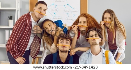 Students having fun together. Group portrait of funny school, college or university friends. Bunch of happy young diverse people with pencil mustaches making funny faces and looking at camera