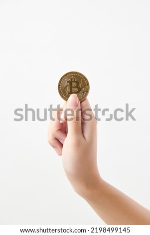 The hand of a woman holding a bitcoin.a virtual currency.