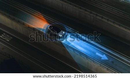 Following Aerial Top Down Drone View: Autonomous Self Driving Car Moving Through City Highway. AI Visualization Concept: High Tech Sensor Scanning Road Ahead for Vehicles, Danger, Speed Limits. Royalty-Free Stock Photo #2198514365