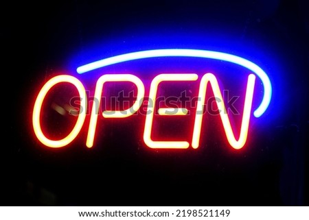 Open sign neon on glass window or door for business at night glowing with color