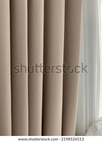 A beuge and white curtain 
