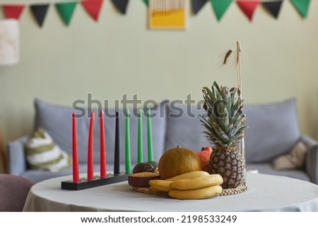 Horizontal image of candles and exotic fruits for Kwanzaa holiday on table in living room
