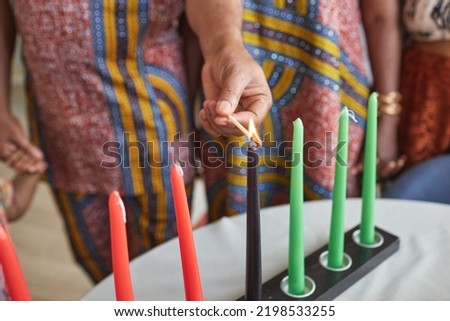 Close-up of family burning candles together for celebration Kwanzaa holiday