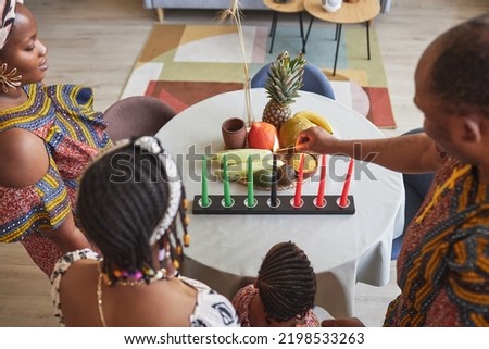Rear view of African family burning seven traditional candles while celebrating Kwanzaa holiday at home