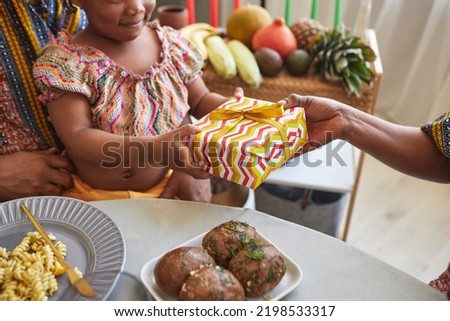 Close-up of African little girl getting present from her parents for holiday