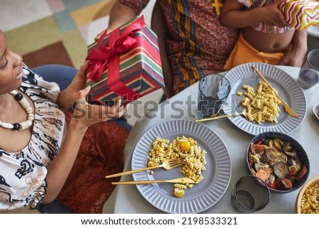 High angle view of African family giving gift boxes to each other at dining table for Kwanzaa holiday