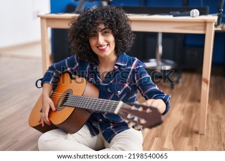 Young middle east woman musician playing classical guitar at music studio Royalty-Free Stock Photo #2198540065