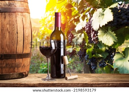Pouring red wine into the glass against wooden background. Royalty-Free Stock Photo #2198593179
