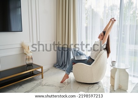Young woman working at home by black notebook. Freelance. interior design