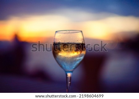 picturesque sunset in glass of white wine, blurred background