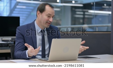 Businessman Talking on Video Call on Laptop in Office