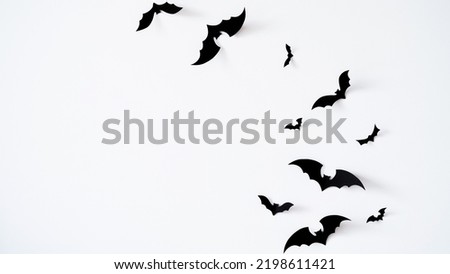 Closeup black paper bats on white wall,copy space,decor for holiday.Interior decoration concept for happy halloween,day of the dead celebration.Top view,flat lay. Holiday postcard.
