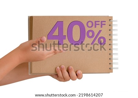 40 percent discount on isolate. Notepad from recycled paper in the hands of a child with text, sale up to 40 percent. The child is holding a notepad demonstrating a big sale.