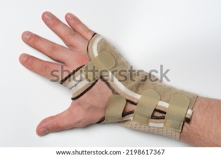 Bandage on hurt hand isolated on white studio background. Pain in hand after using computer mouse