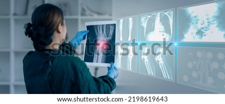 Medicine doctor hand touching on a patients x-ray scans digital healthcare and connection with modern virtual screen interface icons, Medical technology and network concept. Royalty-Free Stock Photo #2198619643