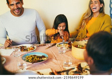Latin parents having fun with children during home dinner - Focus on little girl hand