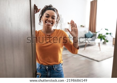 Joyful African American Lady Waving Hello Smililng To Camera Opening Entry Door At Home. Female Gesturing Hi Posing Indoors. Real Estate Property Purchase Concept Royalty-Free Stock Photo #2198686149