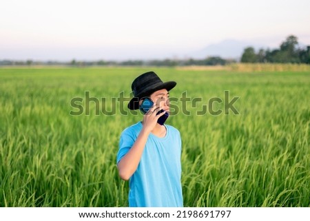 Young millennial smart farmers are busy calling looking at their cellphones in the middle of the rice fields