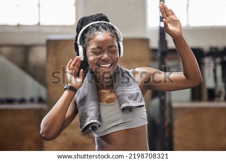 Happy athlete singing and dance with headphone in a gym after fitness, exercise and training. Cheerful woman sweating having fun with music after health and wellness cardio workout in a sports club Royalty-Free Stock Photo #2198708321
