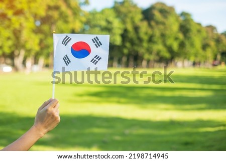 hand holding Korea flag on nature background. National Foundation, Gaecheonjeol, public Nation holiday, National Liberation Day of Korea and happy celebration concepts Royalty-Free Stock Photo #2198714945