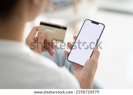 A close-up photo of a young woman using her smartphone and her credit card at home. Online shopping ( credit card mockup )