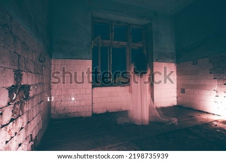 Ghost in abandoned, haunted house. Horror scene of scary spirit of a woman, halloween concept.