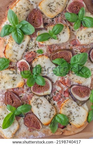 homemade pizza with Italian meat, cheese, figs, arugula, and honey