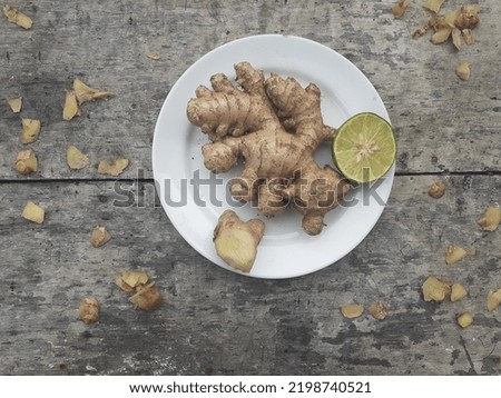 Ginger rhizome on a plate. Wooden background. Ginger rhizome is commonly used as a spice in Indonesian cuisine and traditional medicine. Ginger has a spicy taste due to the ketone compound "zingeron".
