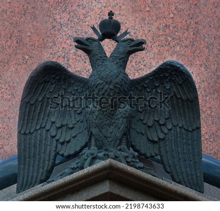 Bronze sculpture of the Russian double-headed eagle on a background of red granite