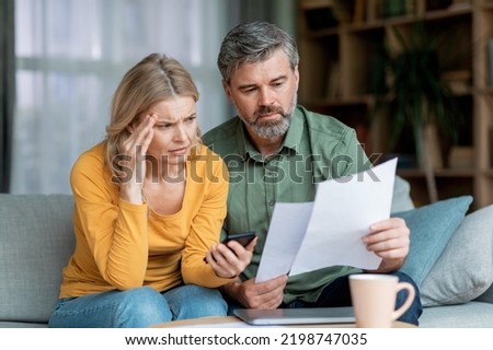 Budget Planning. Stressed Middle Aged Spouses Holding Papers And Calculating Family Spends Together, Thoughtful Mature Spouses Checking Documents, Suffering Financial Crisis, Closeup Shot Royalty-Free Stock Photo #2198747035