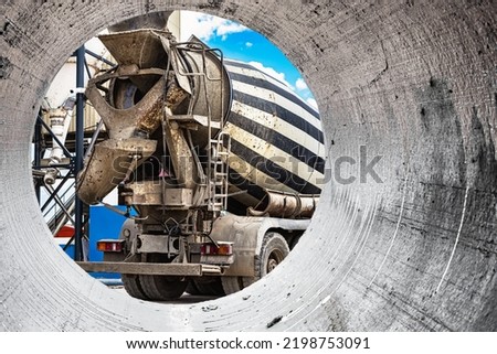 Concrete mixer truck in front of a concrete batching plant, cement factory. Loading concrete mixer truck. Close-up. Delivery of concrete to the construction site. Royalty-Free Stock Photo #2198753091