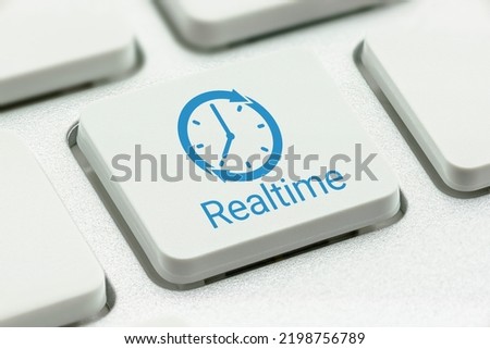 Online payroll payment services and online vendor payment, business concept : Clock logo with the word REALTIME printed on a computer keyboard button, depicting an instant money transfer to a receiver