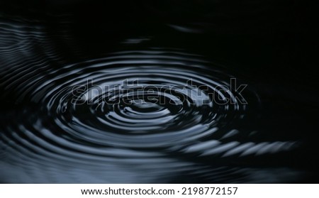 Water ripple or water drop splash on black background. Abstract shape out of the water Royalty-Free Stock Photo #2198772157