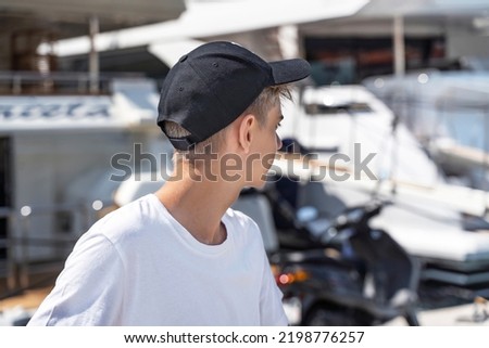 Hipster handsome teenager wear black blank baseball cap with space for your logo or design
