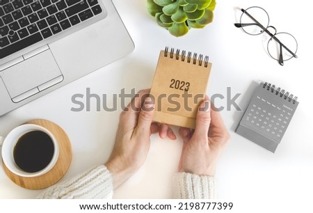 female hand holding table calendar. To-do list and plans for 2023 Goals for next year. Royalty-Free Stock Photo #2198777399