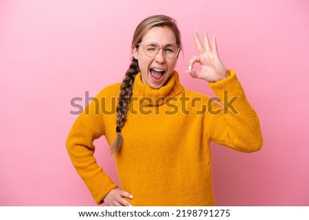 Young caucasian woman isolated on pink background showing ok sign with fingers