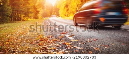 Car on the autumnal asphalt road in countryside Royalty-Free Stock Photo #2198802783