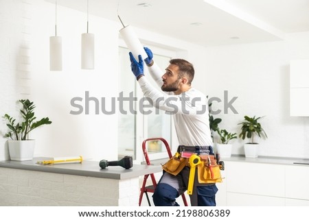 Electrician worker man assembling electric lamps in new apartment. Royalty-Free Stock Photo #2198806389