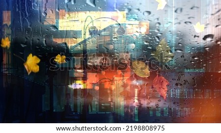 rain drops on window view on evening city stree night blurred light pedestrian and car traffic Autumn background