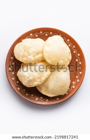 Luchi or Lusi is a deep-fried poori or flatbread, made of Maida flour, originating from Bengal Royalty-Free Stock Photo #2198817241