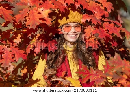 Teen child girl on autumn fall leaves background. smiling kid in sunglasses at autumn leaves on natural background