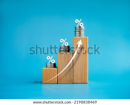 Shining rise up arrow on wooden cube blocks with percentage icon on coin stacked, bar graph chart steps, investment, profit, benefit, income, banking, business growth, economic improvement concepts. Royalty-Free Stock Photo #2198838469