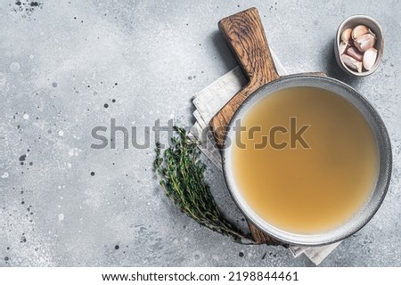 Bone meat chicken broth in a plate. Gray background. Top view. Copy space. Royalty-Free Stock Photo #2198844461